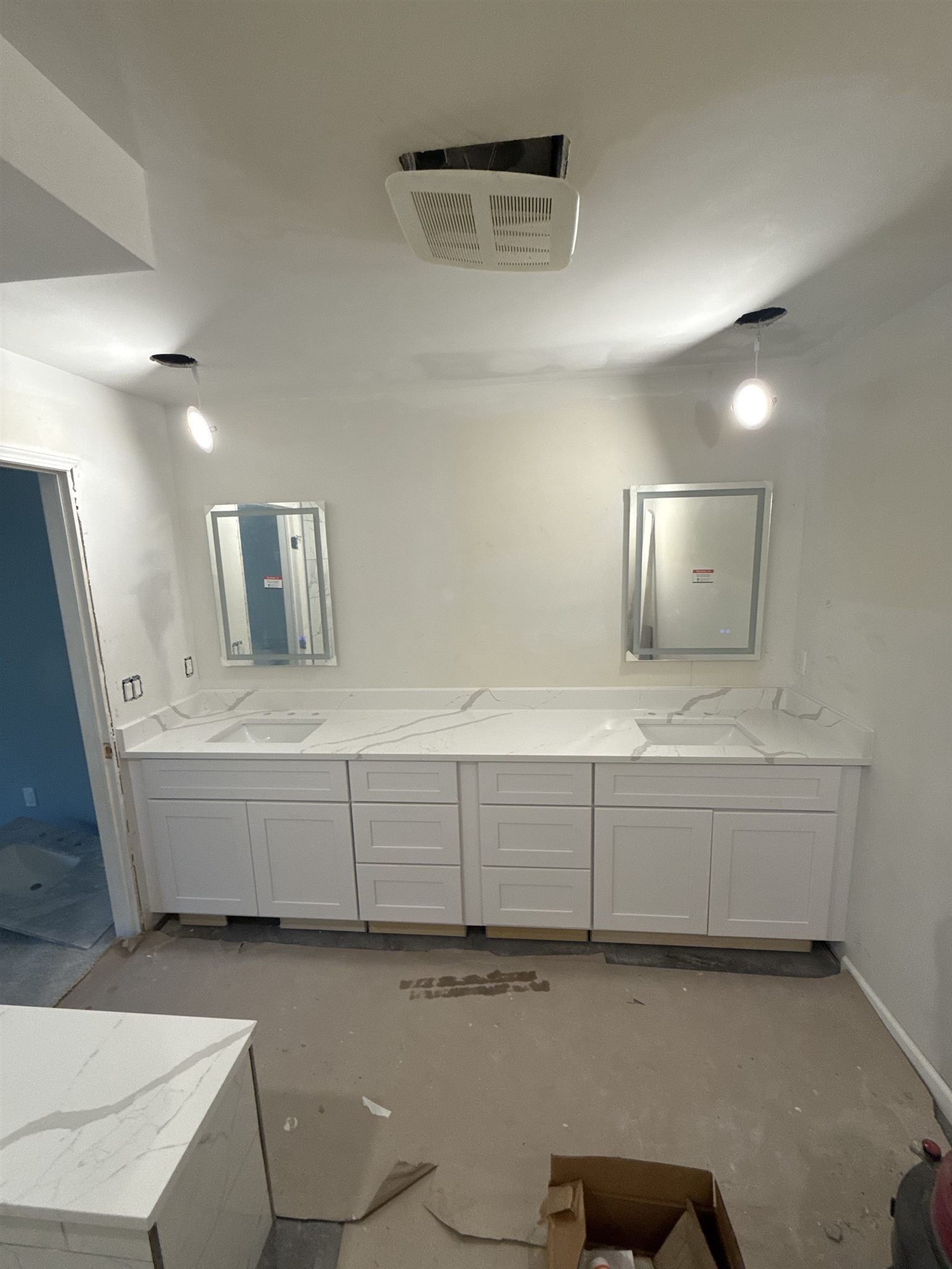 Long white quartz double vanity with two undermount sinks and a matching backsplash